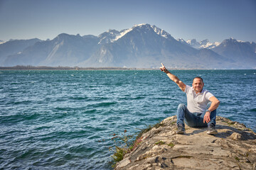 Fototapeta na wymiar Ugly man take a selfie in switzerland lake