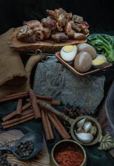 Fototapeta premium Stewed pork leg, Boiled eggs, Tofu and Kale with Spices on dark background. Selective focus.
