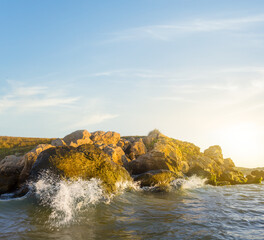 stony sea coast with waves at the sunset, summer sea natural background