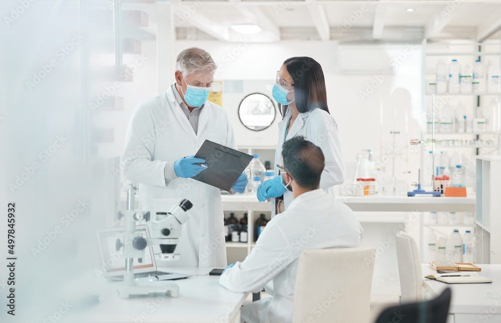 Poster Problem solving is what they do best. Shot of a group of scientists working together in a lab.