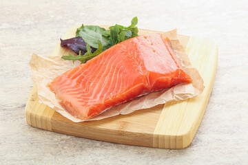 Raw salmon fillet over board