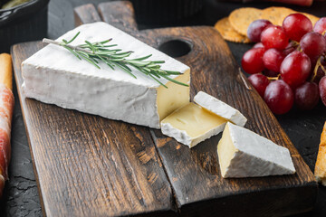 Delicious brie cheese, on black background - obrazy, fototapety, plakaty