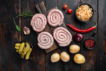 Fried Bavarian German Nürnberger sausages with sauerkraut, mashed potatoes, on old dark  wooden table background, top view flat lay