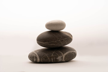 A stack of stones on a white background .Balance and harmony. Copy space.Vertical photo. Spa and healthcare concept.