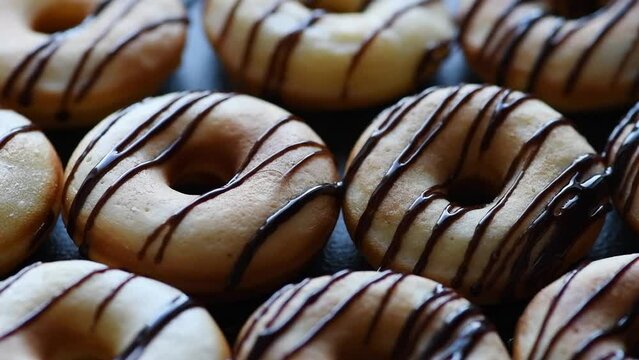 donuts are poured with chocolate, selective focus, slow motion, close-up
