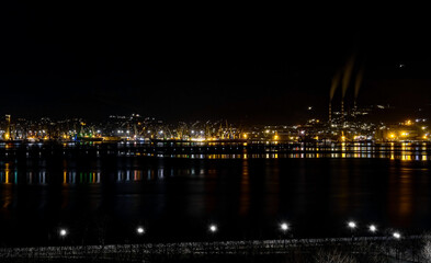 Fototapeta na wymiar Night panoramic view of the port, cranes and other port infrastructure. Novorossiysk trading port on the Black Sea, Tsemesskaya bay