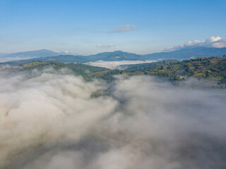 High flight above the clouds in the mountains. Aerial drone view.