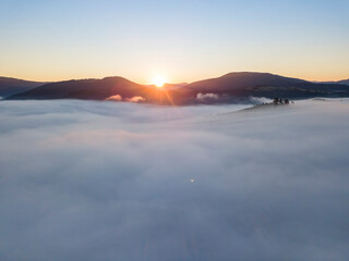 Sunrise over the fog in the Ukrainian Carpathians. Aerial drone view.