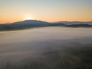 Fototapeta premium Sunrise over the fog in the Ukrainian Carpathians. Aerial drone view.