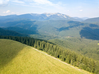 Green mountains of Ukrainian Carpathians in summer. Sunny day, rare clouds. Aerial drone view.