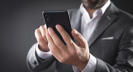Caucasian businessman using smartphone in office.