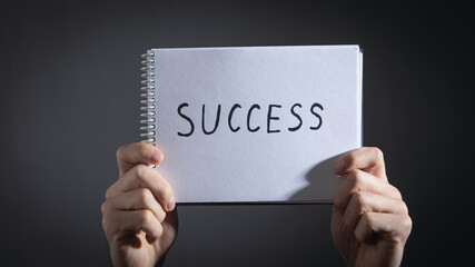 Male hands showing text Success in notepad.