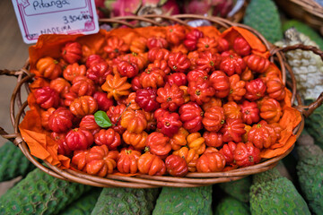 fresh pitanga fruits in wicker basket traditional and tropical Madeira market in Funchal, Portugal