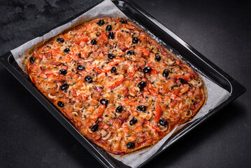 Homemade vegetable pizza with addition of tomatoes, olives and herbs