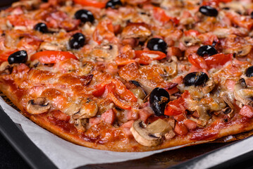 Homemade vegetable pizza with addition of tomatoes, olives and herbs