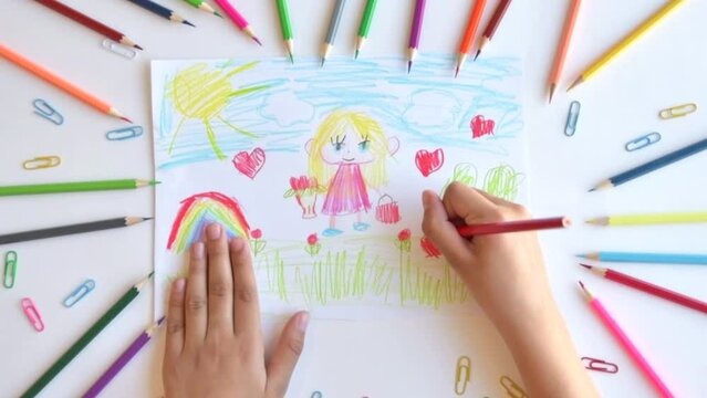 A child draws a postcard for mother's day. Beautiful landscape with mom drawn with pencils