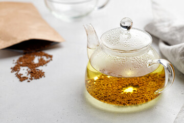 Buckwheat tea and granules in package. Tea in glass transparent teapot. Superfood Taiwan Ku Qiao