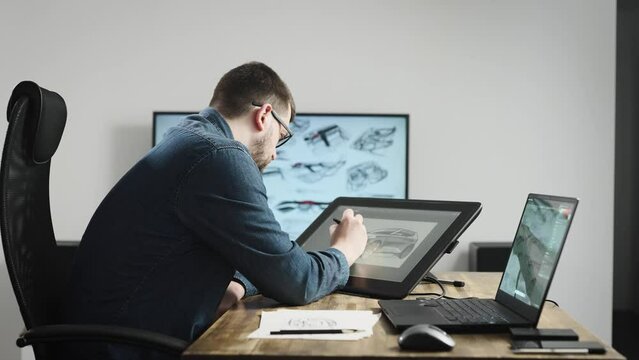 Industrial design studio with graphic tablet and computers. A senior designer draws a new car concept on a tablet.