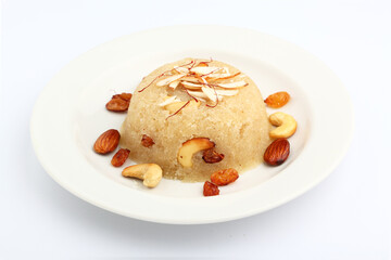 Indian gujrati or maharashtrian or south indian sweet dish SUJI Halwa or sheera or KESARI, famous sweet food in india, also known as halwa, served in white ceramic plate, garnished with dry fruits