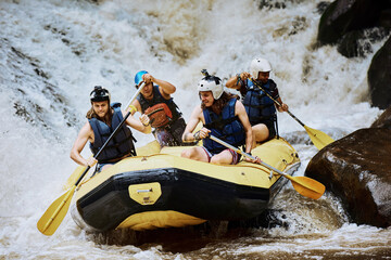 We are a human engine. Shot of a group of determined young men on a rubber boat busy paddling on...