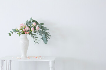 bouquet of pink roses in ceramic white vase  on white vintage wooden shelf