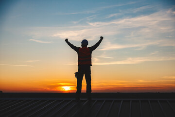 Fototapeta premium A construction worker lifting hands in the air and cheering for success.