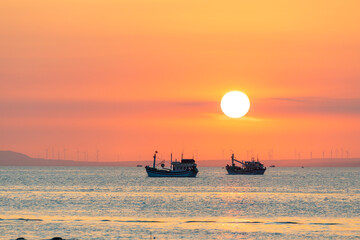 Fototapeta premium Sunset landscape when fishing boats out to sea to harvest fish end the day.