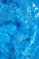 Blue waves ripples and splashes. Blue water texture with lines. Selective focus