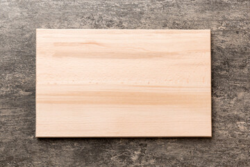 Top view of wooden cutting board on cement background. Empty space for your design