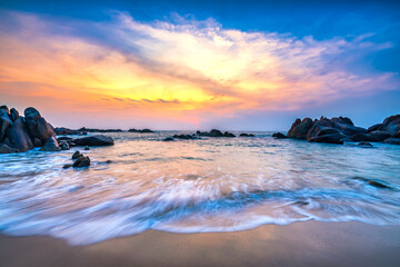 Obraz premium Beautiful beach on sunrise below the waves lapping at the shore of the soft great to welcome the peaceful new day