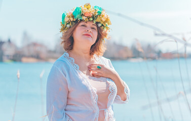 Fototapeta na wymiar Sunny nice Boho ethic style for ladies. Plus size European in floral wreath, model in natural clothes, fashion concept