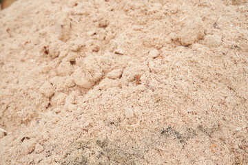 Sawdust stacked in a slide. The background is made of natural sawdust. Recycling of woodworking waste in the workshop. High quality photo
