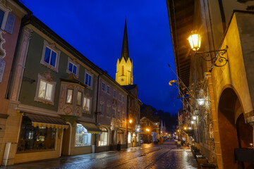 Fototapeta na wymiar Historische Kirche und Straße in der Altstadt von Garmisch-Partenkirchen