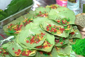 close up photo of a garnished banarasi pan, an indian mouth freshner delicacy made with betel leaves