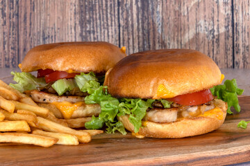 chicken burger with fries on a wooden board
