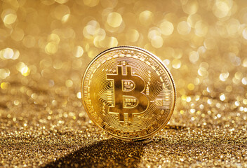 Gold bitcoin coin at the blazing gold background. Conceptual picture of digital money.