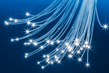 Fototapeta na wymiar Bundle of optical fibers with lights in the ends. Blue background.