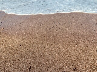 Sand on the beach with a sea wave