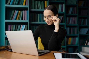 A female programmer works in an office, uses a laptop computer workplace coworking space