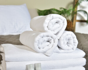 Freshly laundered fluffy towels on bed in hotel