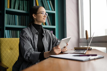 A freelancer woman works in an office, uses the Internet laptop computer workplace coworking space