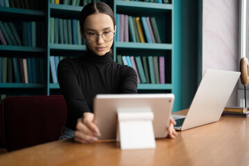 Stylish woman works in an office, uses a laptop computer workplace coworking space