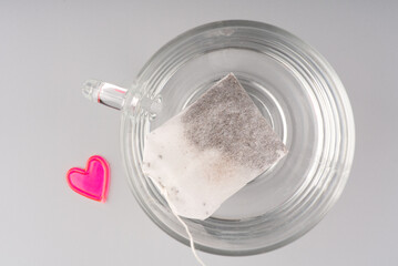 Concept I love tea. The heart lies next to a transparent cup in which the bag and the heart. Space for text