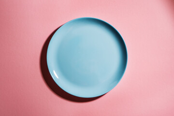 Blue empty plate on pink background