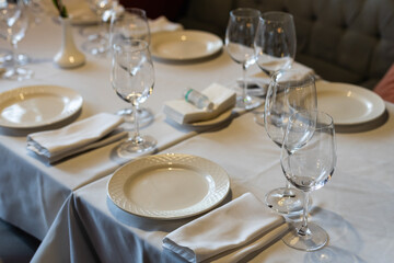 beautifully laid tables with glasses and appliances at morning in restaurant