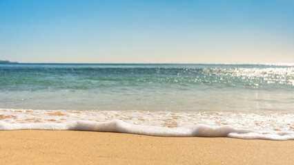 Fototapeta na wymiar wave washing up over the sand on beautiful sunny day