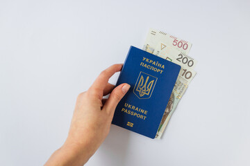 Woman's hand holds Ukrainian biometric passport with payment from United Nations to refugees from Ukraine - 710 PLN.