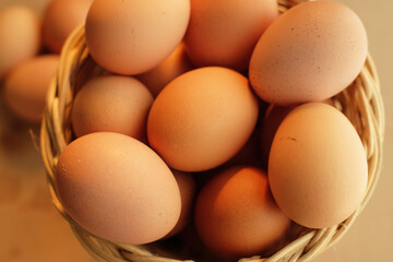 A basket of chicken eggs in warm light on a wooden table