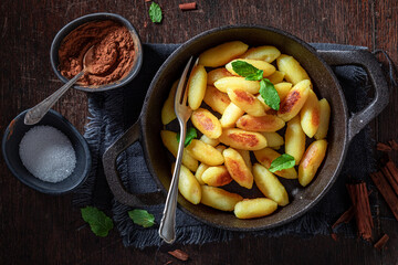 Yummy potato dumplings with sugar, cinnamon and mint leaves.