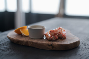 Crab served with sauce and sweet lemon on olive wood board